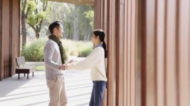 Genç Asyalı çiftler parkta sarılıyorlar.