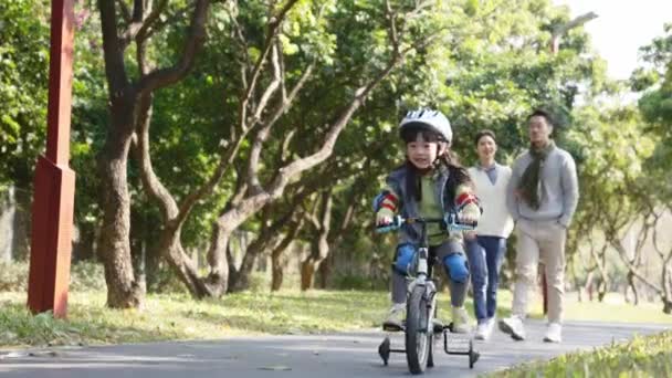 Azji Mała Dziewczynka Jazda Rowerze Parku Rodzicami Spacery Oglądanie Tle — Wideo stockowe
