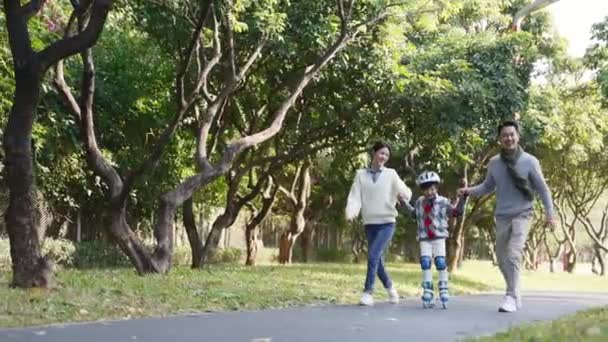 Kleiner Asiatischer Junge Lernt Rollschuhlaufen Park Mit Hilfe Junger Eltern — Stockvideo