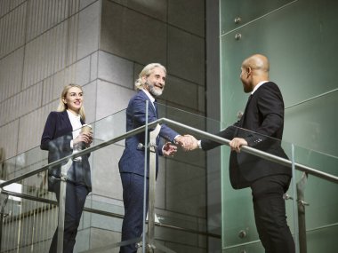 modern ofis binası, el sallayarak çok ırklı şirket yöneticileri düşük açılı görünüş.