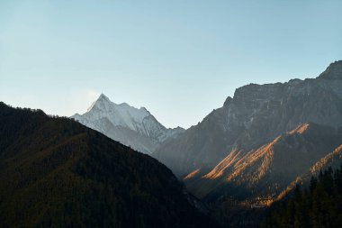 Yading Ulusal Parkı, Daocheng Bölgesi, Sichuan Bölgesi, Çin 'de sonbahar yeşillikleri olan bir dağ sırası.