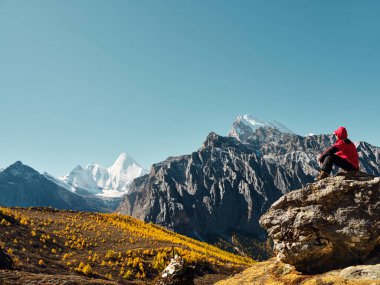 Yading, Daocheng County, Sichuan Eyaleti, Çin 'deki Yangmaiyong' a (veya Tibet 'te Jampayang) bakan Asyalı bir adam.