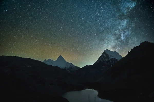 Galaksinin ve yıldızlı gökyüzünün dağların ve gölün üzerinden milli park, Daocheng ilçesi, sichuan vilayeti, Çin 'de uzun pozlu görüntüleri.