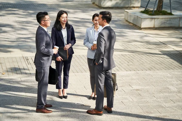 Skupina Čtyř Mladých Asijských Podnikatelů Stojí Chatování Venku Ulici — Stock fotografie
