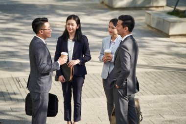 Asyalı dört genç iş adamından oluşan bir grup sokakta sohbet ediyorlar.