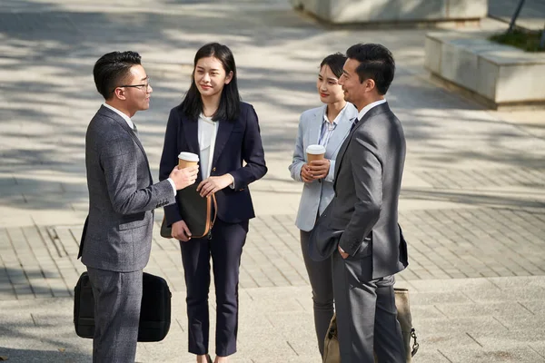 Skupina Čtyř Mladých Asijských Podnikatelů Stojí Chatování Venku Ulici — Stock fotografie