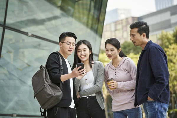 Bir Grup Asyalı Birlikte Cep Telefonuna Bakıp Mutlu Gülümsüyor — Stok fotoğraf