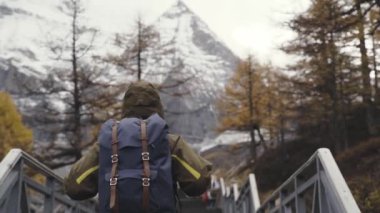 Asyalı erkek turist gezgin Xiannairi dağına tırmanıyor Yading Ulusal Parkı, Sicuan, Çin 
