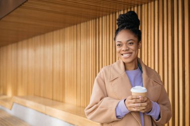Güzel bir Afro-Amerikan kadının portresi. Kahve içiyor. Gözlerini kaçırıyor, sokakta yürüyor, uzayı kopyalıyor.