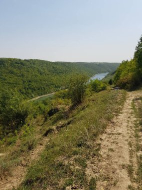  Ağaçlarla, dağlarla, nehirlerle dolu bir manzara.