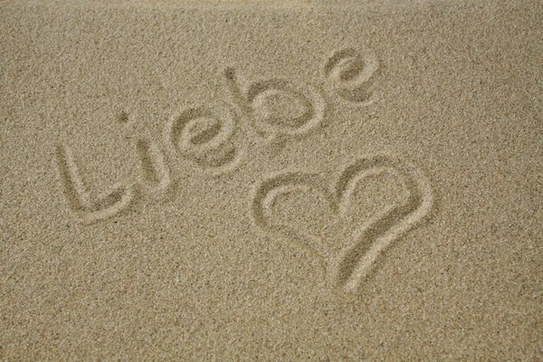 Das Wort Liebe im Sand mit Herz — Stockfoto