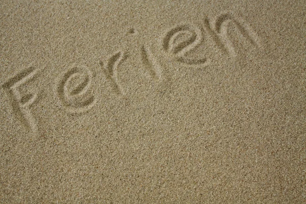 Slovo dovolená v písku — Stock fotografie