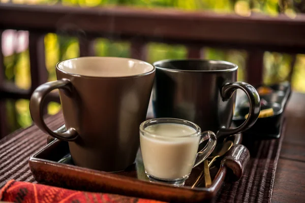 Tazza di tè con latte al tavolo di legno — Foto Stock