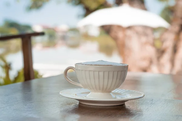 Tazza di caffè in un caffè sotto l'ombrello — Foto Stock