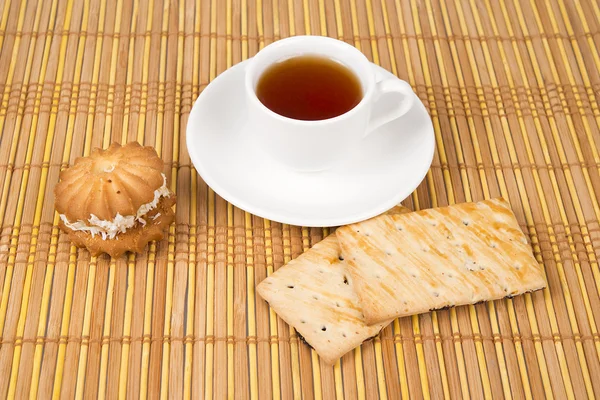 Pastel de coco dulce y taza de té en estera de bambú —  Fotos de Stock
