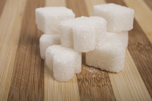 Sugar cubes on a wooden board — Stock Photo, Image