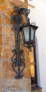 Old iron street lantern on a stone wall