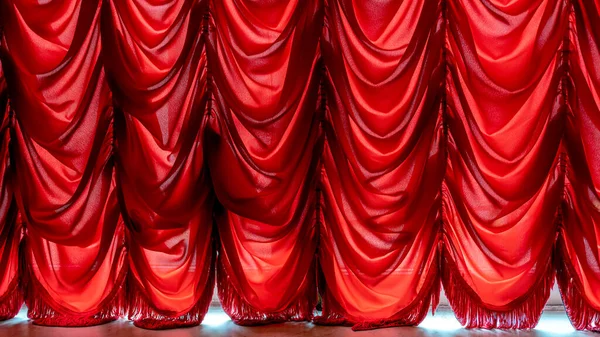 Old style translucent red curtain on window. Sunny light in house room.