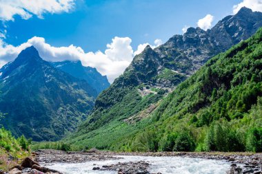 Photo View of the mountain river in the gorge, North Ossetia, Russia. Impenetrable rocks, majestic sun, mountains and forests.
