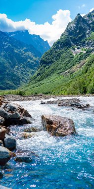 View of the mountain river in the gorge, North Ossetia, Russia. Impenetrable rocks, majestic sun, mountains and forests.