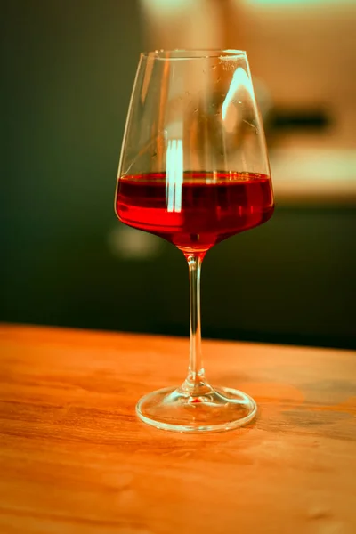 Há um copo de vinho tinto na mesa. — Fotografia de Stock