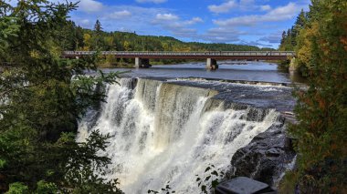 The sun lights up the water , rocks, sky and the clouds - Kakabeka Falls, Thunder Bay, ON, Canada