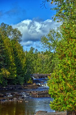 Mavi gökyüzü, bulutlar, şelaleler ve bitki örtüsüyle güzel parlak bir gün - Trowbridge Şelalesi, Thunder Bay, on, Canada