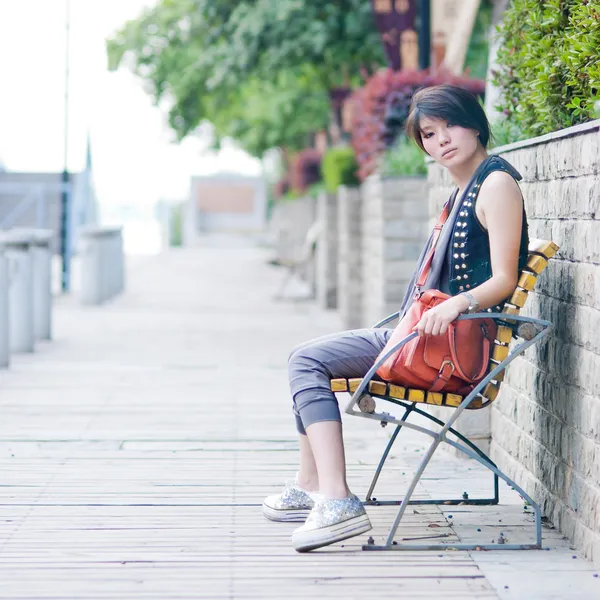 Girl sitting in chair outdoor — Stock Photo, Image