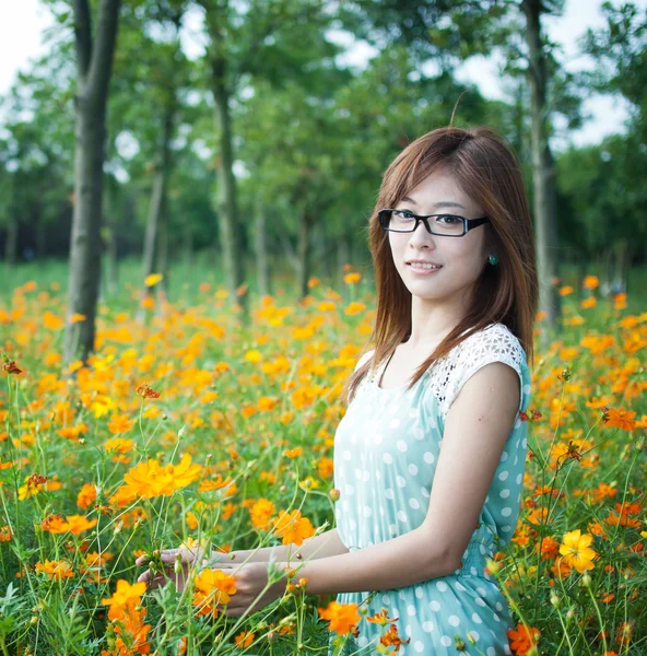 Chica joven en un campo de flores — Foto de Stock