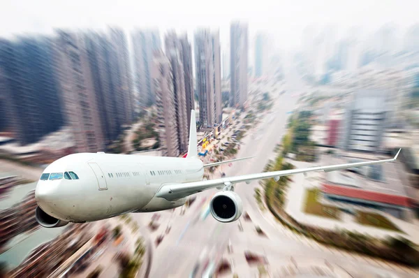The airplane away from the city — Stock Photo, Image