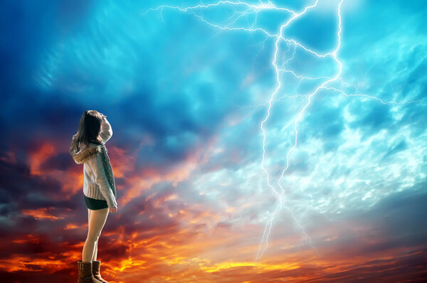Girl looking at the lightning in the sky