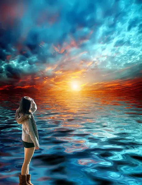 Güzel genç bir kadın gün batımında neşe içinde denize ve gökyüzüne baktı. — Stok fotoğraf