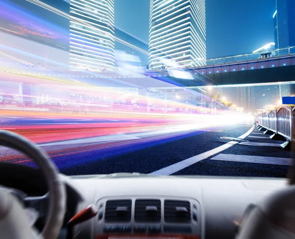 Driver's hands on a steering wheel of a car and night scene — Stock Photo, Image