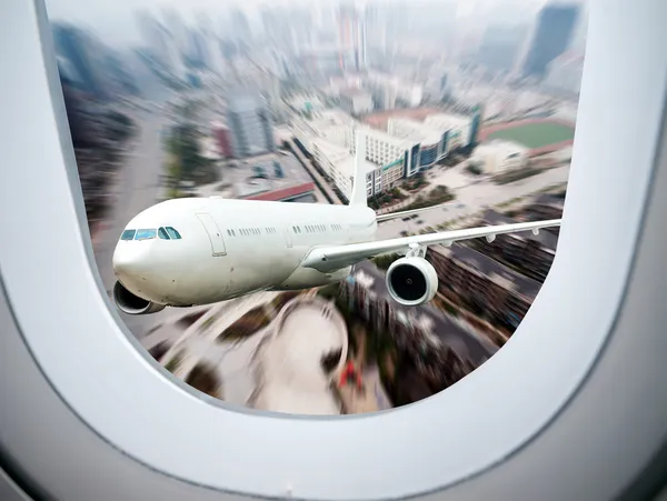 A través de las ventanas de los aviones, el avión lejos de la ciudad — Foto de Stock