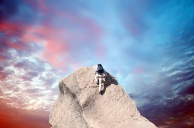 genç adam arka planı mavi gökyüzü ile kireçtaşı duvara tırmanma