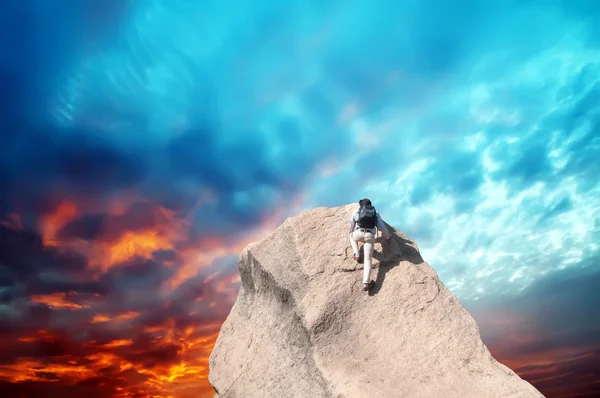 Jovem escalando uma parede de pedra calcária com céu azul no fundo — Fotografia de Stock