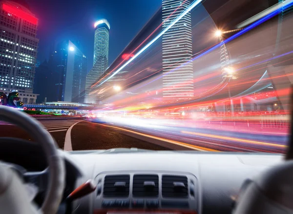 Driver's hands on a steering wheel of a car and night scene — Stock Photo, Image