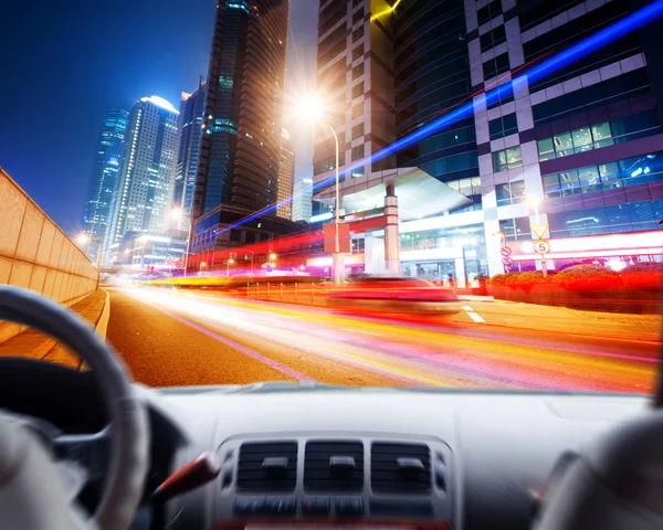 Driver's hands on a steering wheel of a car and night scene — Stock Photo, Image