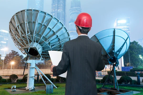 Backside of man and antenna against blue sky — Stock Photo, Image