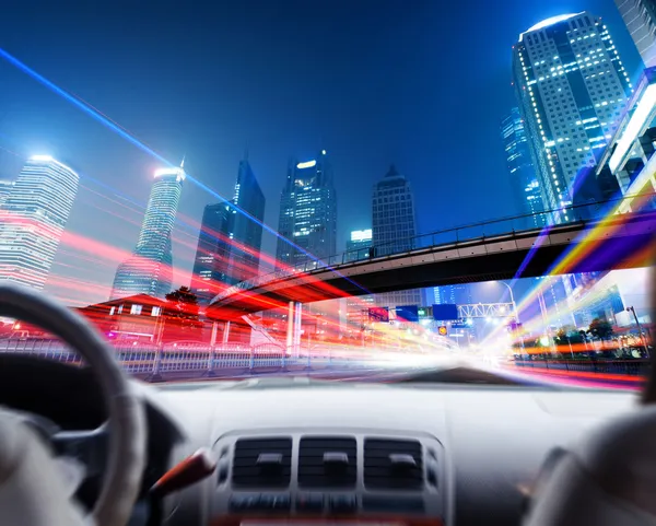 Driver's hands on a steering wheel of a car and night scene — Stock Photo, Image