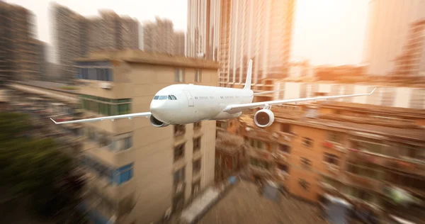 The airplane away from the city — Stock Photo, Image