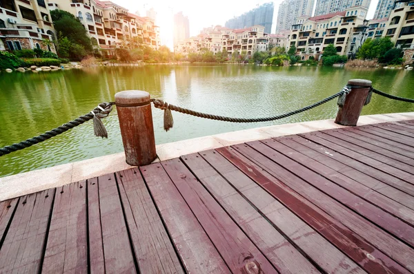 Plataforma ao lado do lago com pôr do sol no parque — Fotografia de Stock