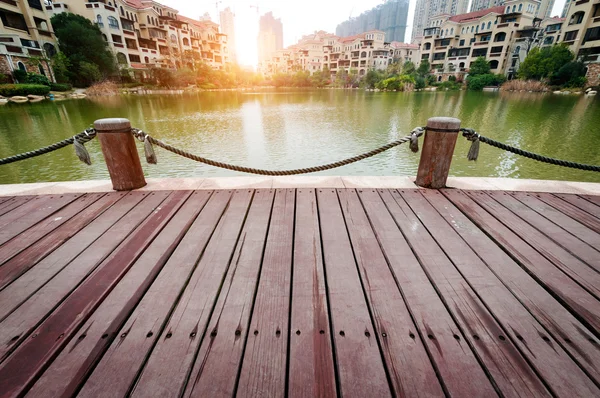 Piattaforma accanto al lago con tramonto in parco — Foto Stock