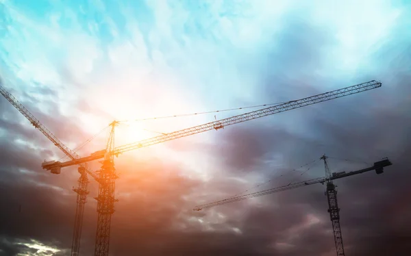 Bouwmachines en elementen van een gebouw in aanbouw bij zonsondergang — Stockfoto