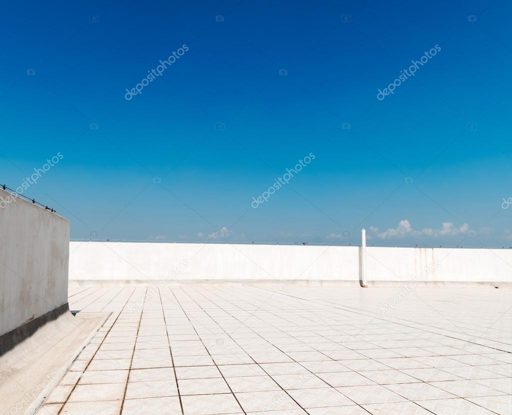 Balcony, floor, concrete fence and blue sky. Outdoor architecture, bottom perspective