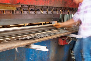 Levha metal ve elleri baskı makinesinde çalışan işçinin