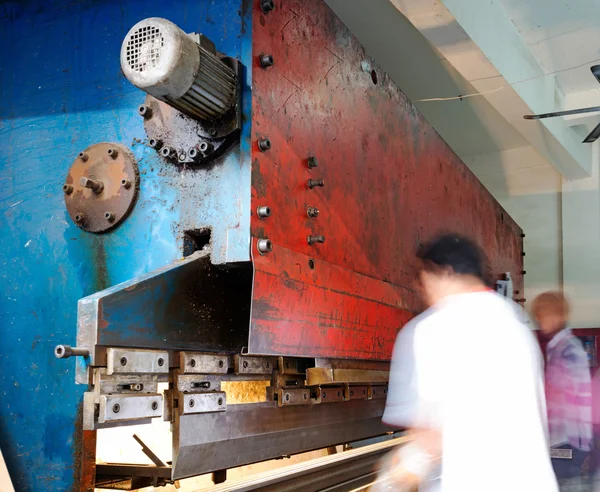 Levha metal ve elleri baskı makinesinde çalışan işçinin