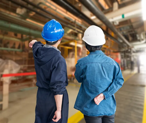 A team of construction workers with helmets at work place in a f — Stock Photo, Image