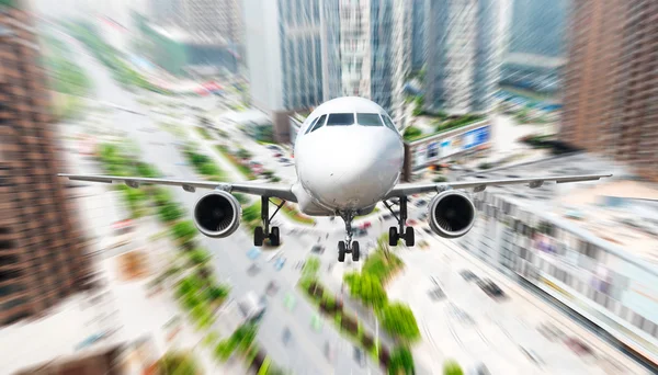 The airplane away from the city — Stock Photo, Image