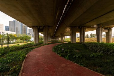 Şehirdeki üst geçidin altında beton yapı ve asfalt yol alanı
